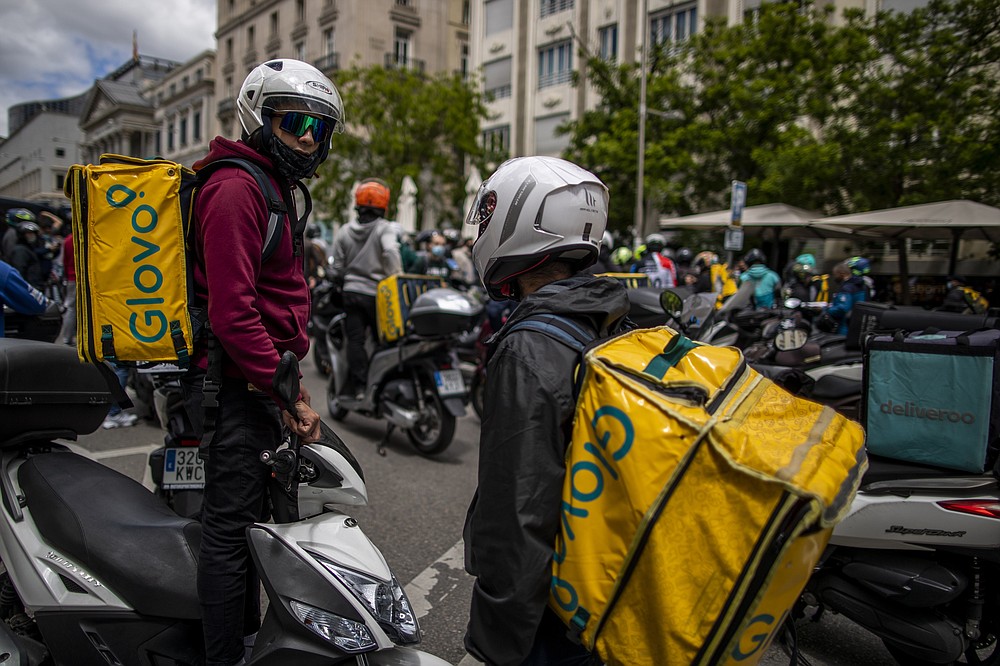 Los trabajadores de reparto protestan frente al Parlamento español en Madrid, España, el martes 11 de mayo de 2021. España aprobó una ley pionera que otorga a las plataformas de reparto una fecha límite a mediados de agosto para contratar trabajadores que actualmente son autónomos y requiere una transparencia artificialmente inteligente para gestionar la fuerza laboral.  (Foto AP / Manu Fernandez)