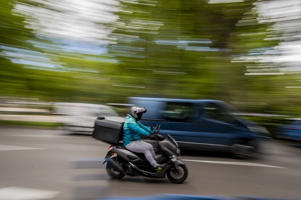 Un trabajador de reparto conduce su motocicleta en Madrid, España, el martes 11 de mayo de 2021. España aprobó una ley pionera que otorga a las plataformas de reparto una fecha límite a mediados de agosto para contratar trabajadores que actualmente son autónomos y requiere transparencia de AI para gestionar el personal.  (Foto AP / Manu Fernandez)