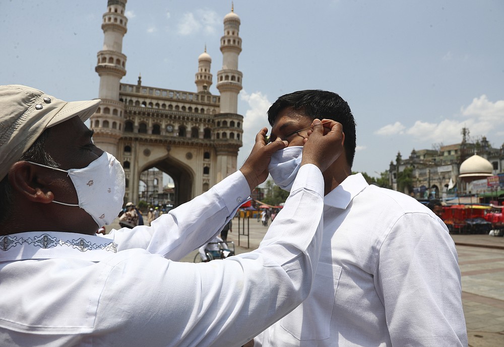 FILE- In this May 7, 2021, file photo, an Indian Muslim wearing face mask as a precaution against coronavirus gets his eyes lined with a black ointment called Surma before offering last Friday prayers of Ramadan at Mecca Mosque in Hyderabad, India. Misinformation about the coronavirus is surging in India as the death toll from COVID-19 rises. Fueled by anguish, distrust and political polarization, the claims are further compounding India's crisis. (AP Photo /Mahesh Kumar A, File)