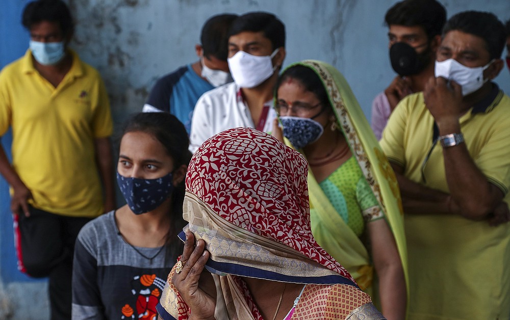 FILE- In this April 19, 2021, file photo, people wearing masks as a precaution against the coronavirus wait to test for COVID-19 at a hospital in Hyderabad, India. Misinformation about the coronavirus is surging in India as the death toll from COVID-19 rises. Fueled by anguish, distrust and political polarization, the claims are further compounding India's crisis. (AP Photo/Mahesh Kumar A, File)