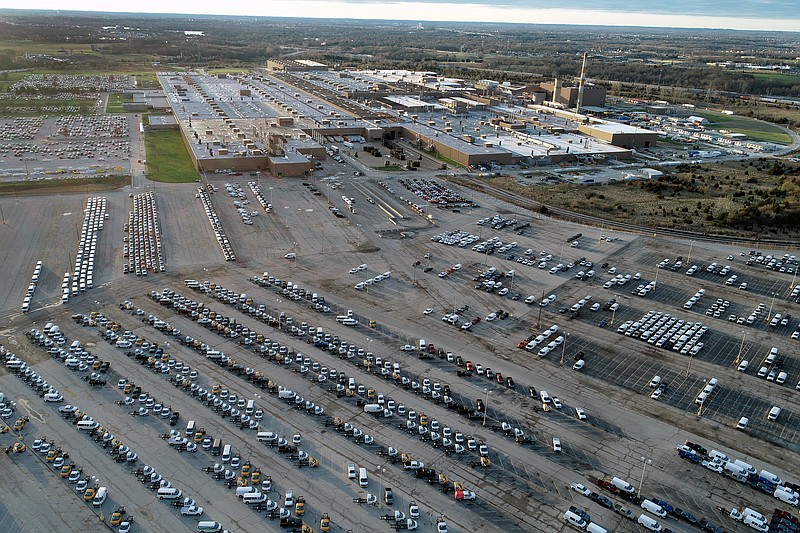 In this aerial photo, a General Motors assembly plant is seen at top right while mid-sized pickup trucks and full-size vans currently produced at the plant are seen in a parking lot outside Wednesday, March 24, 2021, in Wentzville, Mo.  U.S. industrial production increased for a second straight month as more factories came online after being shutdown by winter ice storms. Industrial production — which includes output at factories, mines and utilities — rose 0.7% in April, down from a sharp gain of 2.4% drop in March, the Federal Reserve reported Friday, May 14.  (AP Photo/Jeff Roberson)