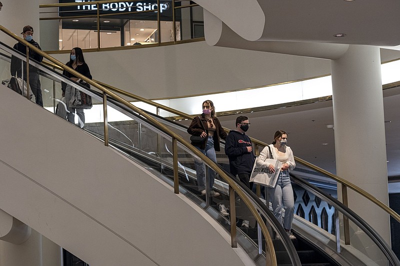 Shoppers wearing protective masks ride an escalator inside the Westfield San Francisco Centre shopping mall in San Francisco on March 9, 2021. MUST CREDIT: Bloomberg photo by David Paul Morris.