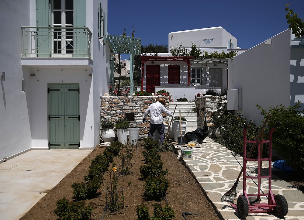 Ένας άντρας καθαρίζει έναν κήπο ξενοδοχείου στο χωριό Άγιος Προκόπιος, στο νησί της Νάξου στο Αιγαίο Πέλαγος, Τετάρτη 12 Μαΐου 2021 (AP Photo / Θανάσης Σταυράκης)