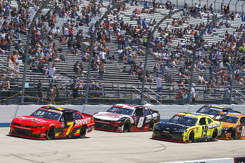 Justin Allgaier, left, leads the field with Josh Berry, center, and Brandon Jones, right, right behind him during a NASCAR Xfinity Series auto race at Dover International Speedway, Tuesday, June 15, 2021, in Dover, Del. (AP Photo/Chris Szagola)