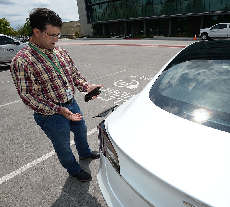 Kris Williams, director of energy services for Ozarks Electric Cooperative Corp. demonstrates how one of the cooperative‚Ä∞√õ¬™s Tesla Model 3 electric vehicles is charged Wednesday, May 12, 2021, at the cooperative‚Ä∞√õ¬™s offices in Fayetteville. It can be challenging to find charging stations for electric vehicles in rural areas of Arkansas, but both the state and private companies are working to change that. Visit nwaonline.com/210518Daily/ for today's photo gallery. 
(NWA Democrat-Gazette/Andy Shupe)