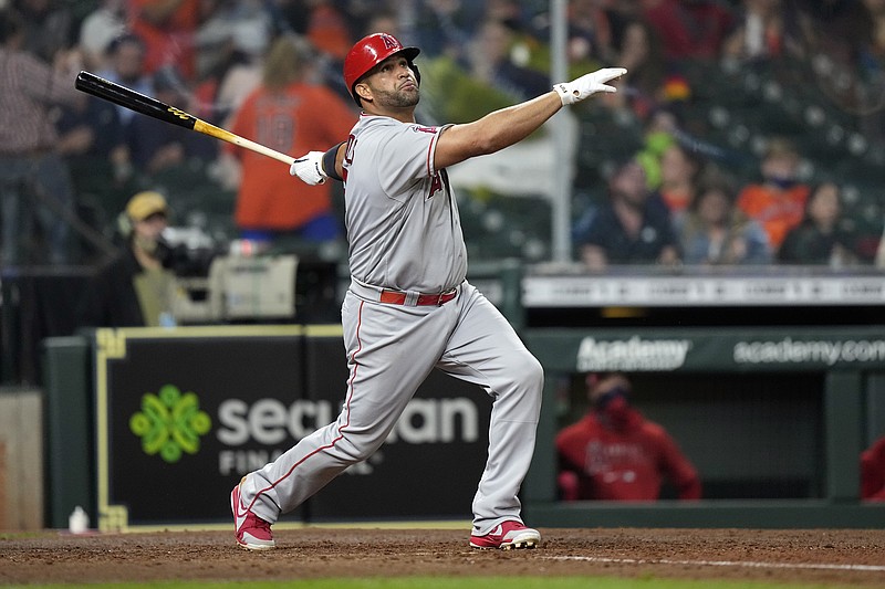 FILE - Los Angeles Angels' Albert Pujols hits a two-run home run against the Houston Astros during the sixth inning of a baseball game in Houston, in this Thursday, April 22, 2021, file photo. Pujols has been designated for assignment by the Los Angeles Angels, abruptly ending the 41-year-old superstar slugger's decade with his second major league team. The Angels announced the move Thursday, May 6, 2021, a day after Pujols wasn't in their lineup for their fourth consecutive loss.  (AP Photo/David J. Phillip, File)