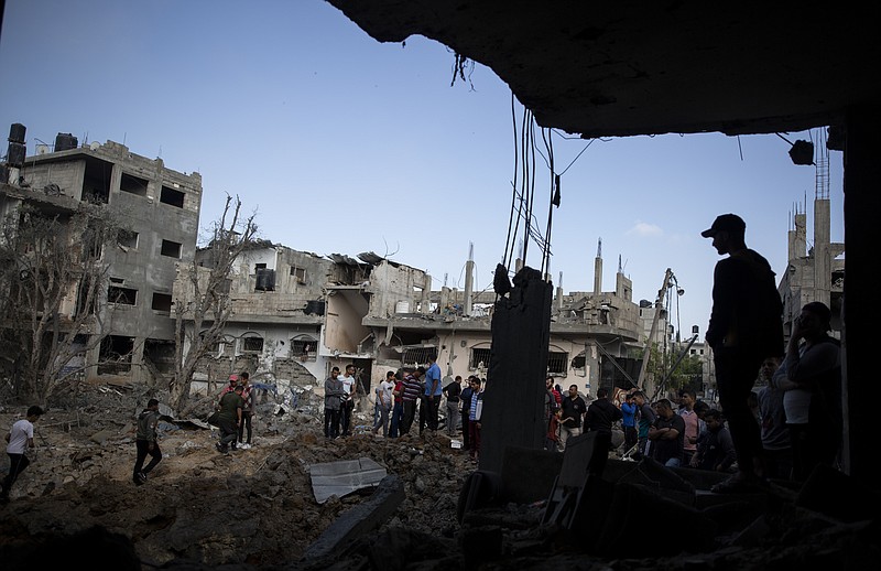 Palestinians inspect their destroyed houses following overnight Israeli airstrikes in town of Beit Hanoun, northern Gaza Strip, Friday, May 14, 2021. (AP Photo/Khalil Hamra)