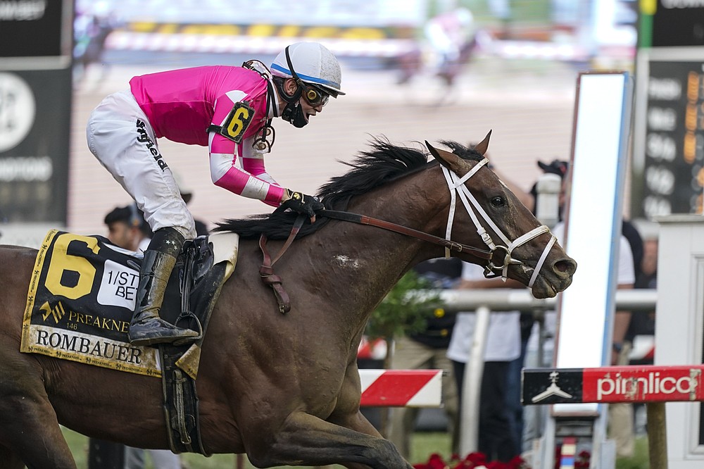 Flavien Prat atop Rombauer reacts as he crosses the finish line to win the Preakness Stakes horse race at Pimlico Race Course, Saturday, May 15, 2021, in Baltimore. (AP Photo/Julio Cortez)