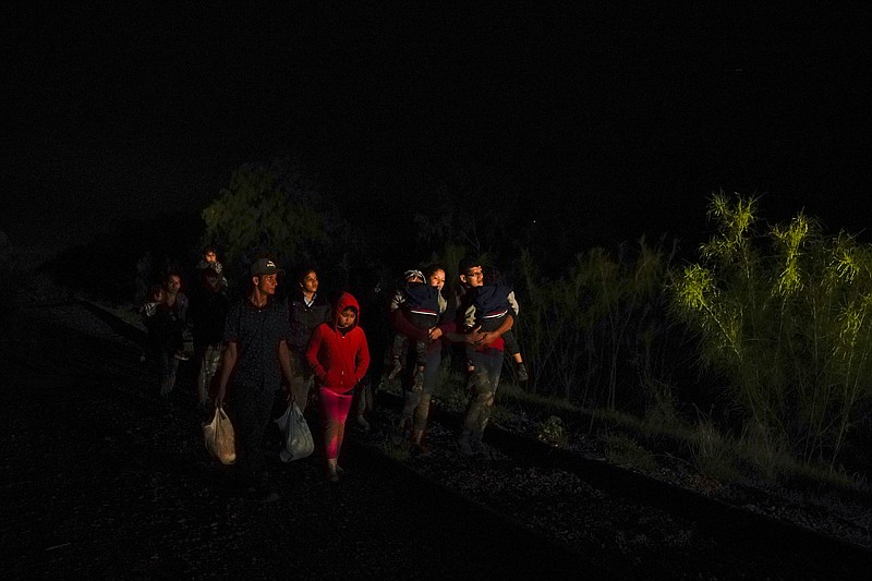 Emely, 8, of Honduras, center, walks with a group of migrants after turning themselves in upon crossing the U.S.-Mexico border Wednesday, May 12, 2021, in La Joya, Texas. Growing numbers of migrant families are making the heart-wrenching decision to separate from their children and send them into the U.S. alone.  (AP Photo/Gregory Bull)