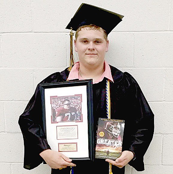STAFF PHOTO/Prairie Grove 2021 graduate Seth Vaughn received the Brandon Burlsworth Character Award, which honors a player, who may or not be a top athletic performer, yet represents the ideals and values epitomized by the late Brandon Burlsworth — to give 100 percent on the field and to stand as a moral example to his team. The Burlsworth Foundation hopes the award encourages each recipient to continue on his path of excellence and inspire others to follow his head. Prairie Grove head football coach Danny Abshier presented the award to Vaughn.