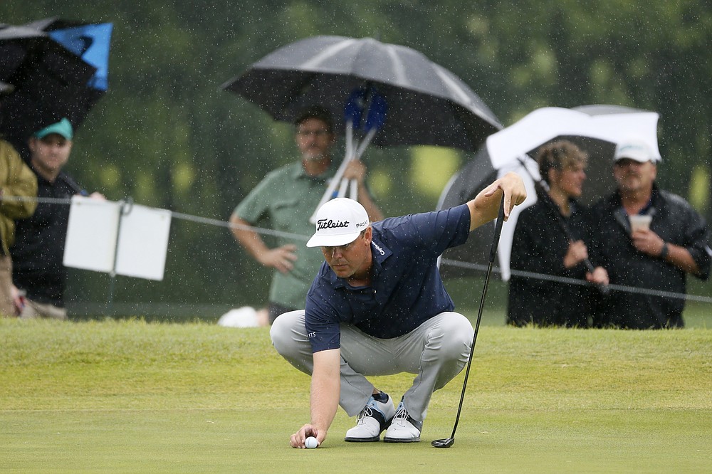 Patton Kizzire works in a pouring rain as he prepares to putt on the 18th green during the final round of the AT&T Byron Nelson golf tournament in McKinney, Texas, Sunday, May 16, 2021. (AP Photo/Ray Carlin)