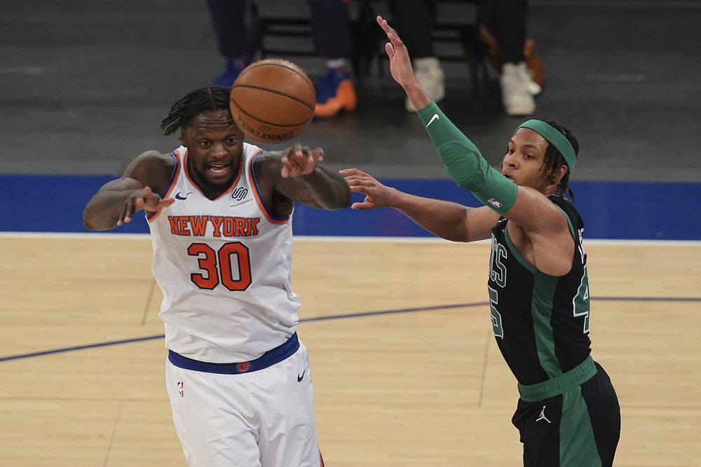 New York Knicks forward Julius Randle (30) passes the ball against Boston Celtics guard Romeo Langford (45) during the second half of an NBA basketball game in New York, Sunday, May 16, 2021. (Vincent Carchietta/Pool Photo via AP)