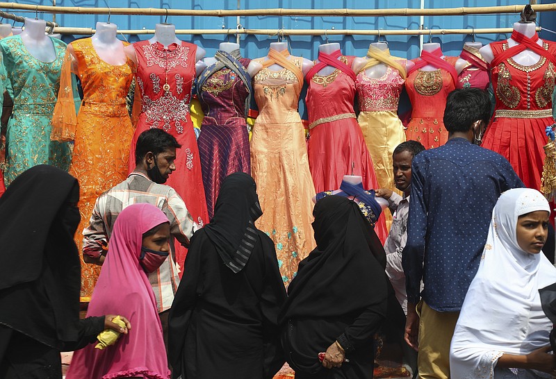 FILE - In this May 13, 2021, file photo, Indian Muslims shop during a relaxation of lockdown to curb the spread of the coronavirus on the eve of Eid-al-Fitr in Hyderabad, India. A dip in the number of coronavirus cases in Mumbai is offering a glimmer of hope for India, which is suffering through a surge of infections. But experts say the crisis is far from over in the country of nearly 1.4 billion people, with hospitals still overwhelmed and officials struggling with short supplies of oxygen and beds. (AP Photo/Mahesh Kumar A, File)