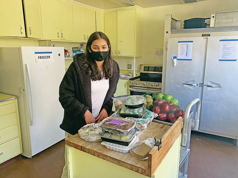 Vedika Jawa poses with freshly baked desserts inside South Hayward Parish in Fremont, Calif., on Feb. 1, 2021. Jawa, a high school junior, distributes sweets to 15 shelters through a non-profit she started when she was 13. (Rachna Jawa via AP)