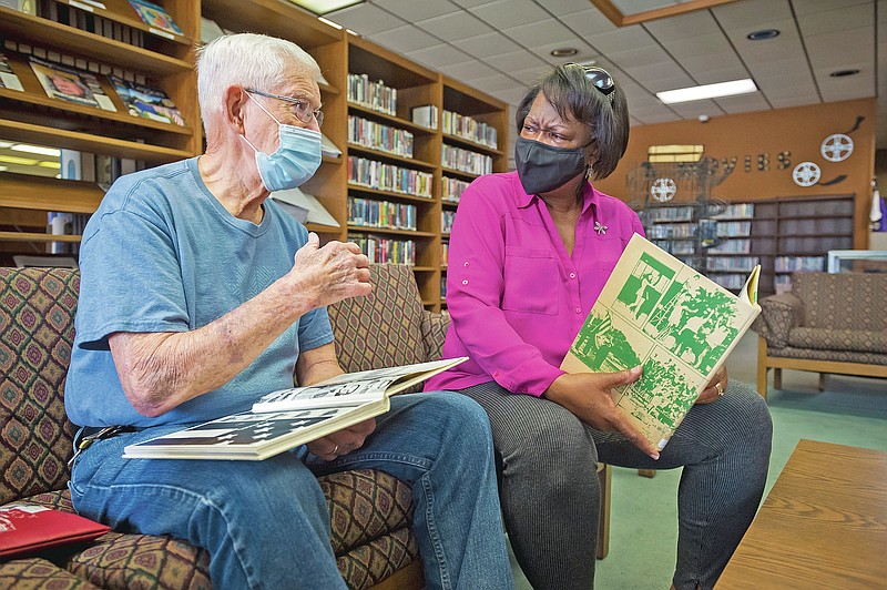 Antoinette Pete and Jimmy Meche look at Crowley High School yearbooks from the early 1970s at the Acadia Parish Public Library Monday, April 26, 2021 in Crowley, La. Pete was a ninth-grader and Meche her assistant principal when the school was integrated in 1971. (Scott Clause/The Daily Advertiser via AP)