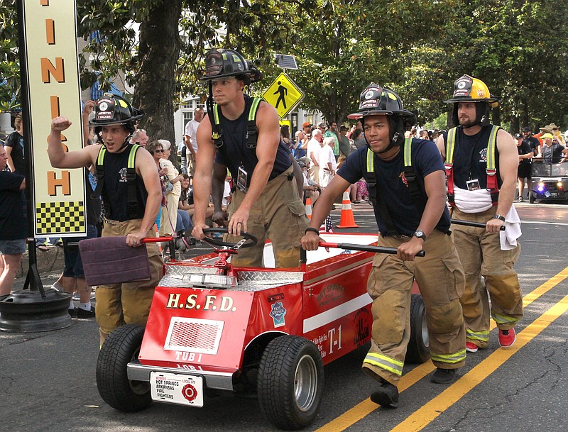 Members of the Hot Springs Fire Department team take part in the Parade of Tubs during the 12th Annual Stueart Pennington Running of the Tubs in June 2017. - File photo by The Sentinel-Record