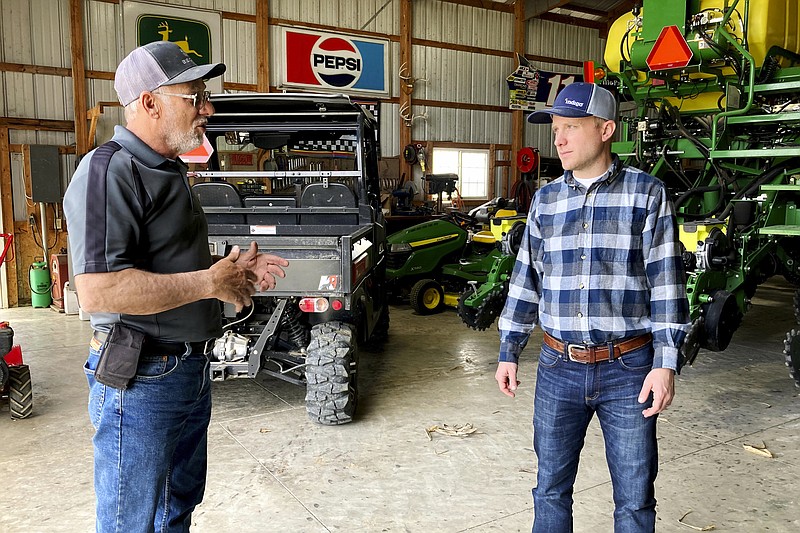 Farmer Rick Clifton, left, talks with Bryan Randall, an agronomist with Indigo Agriculture in Orient, Ohio, on April 5. Indigo pays Clifton and other producers to use techniques that keep carbon in the soil instead of releasing it to the atmosphere. Clifton grows cereal rye and rapeseed as off-season cover crops and uses no-till cultivation. - AP Photo/John Flesher
