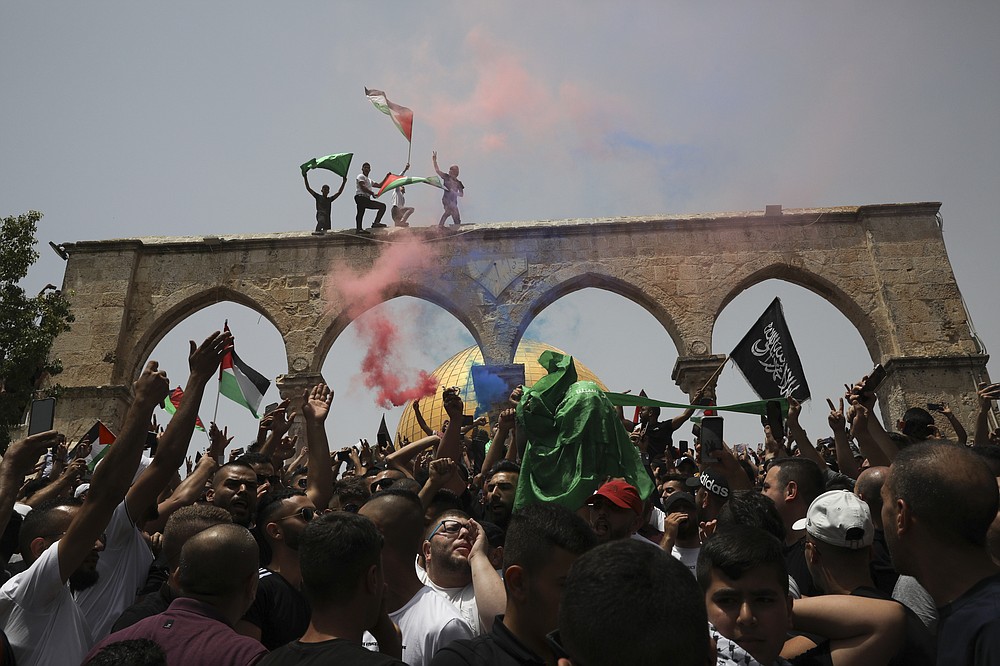 Palestinians wave national flags in front of the Dome of the Rock in the al-Aqsa mosque complex in Jerusalem, Friday, May 21, 202, as a cease-fire took effect between Hamas and Israel after an 11-day war. (AP Photo/Mahmoud Illean)