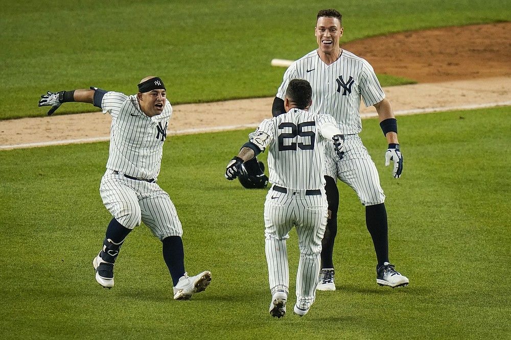New York Yankees' Gleyber Torres (25) celebrates with Rougned Odor, left, and Aaron Judge, right, after hitting an RBI-single during the ninth inning of a baseball game against the Chicago White Sox, Friday, May 21, 2021, in New York. (AP Photo/Frank Franklin II)