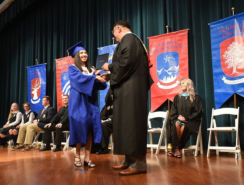 ACADEMY'S FIRST GRADUATES
Tania Mares receives her high school dipoloma on Saturday May 22 2021 from John Rocha, head of school at Ozark Catholic Academy in Tontitown. Twelve graduates received their diplomas in the Jones Center for Families in Springdale. They are the first graduates from the Catholic high school, which opened in 2018. Go to nwaonline.com/210523Daily/ to see more photos.
(NWA Democrat-Gazette/Flip Putthoff)