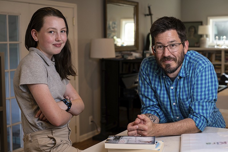 Jay Wamsted, right, and his daughter, Kira, are photographed on Thursday, May 20, 2021 in Smyrna, Ga.  Wamsted,  who is an 8th grade math teacher allowed his daughter to skip testing this year.   With new flexibility from the Biden administration, states are adopting a patchwork of testing plans that aim to curb the stress of exams while still capturing some data on student learning. (AP Photo/Ben Gray)