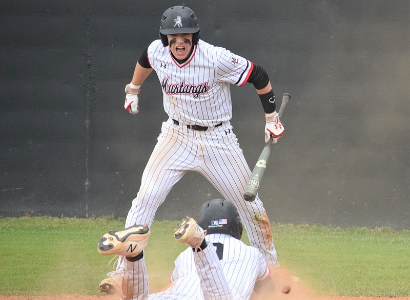 RICK PECK/SPECIAL TO MCDONALD COUNTY PRESS McDonald Counjty's Cross Dowd celebrates as teammate Cole Martin scores a run during the Mustangs' 10-4 win over West Plains in the opening round of the Missouri Class 5 District 6  Baseball Tournament on May 18 at MCHS.