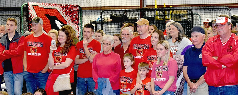 MARK HUMPHREY  ENTERPRISE-LEADER/Multi-generational members of Randy Osnes' family including his parents, Dale and Betty Harp (center), children and grandchildren, along with a host of well-wishers applaud during a ceremony officially changing the name of Farmington's Lady Cardinal Field to Randy Osnes Field following a rain-shortened five inning, 6-1, win by the Lady Cardinals over rival Prairie Grove Friday. A special senior night ceremony was also conducted recognizing Class of 2021 seniors from both Farmington and Prairie Grove as well as the 2020 Farmington seniors, who didn't get a senior night due to cancellation of their season because of covid.