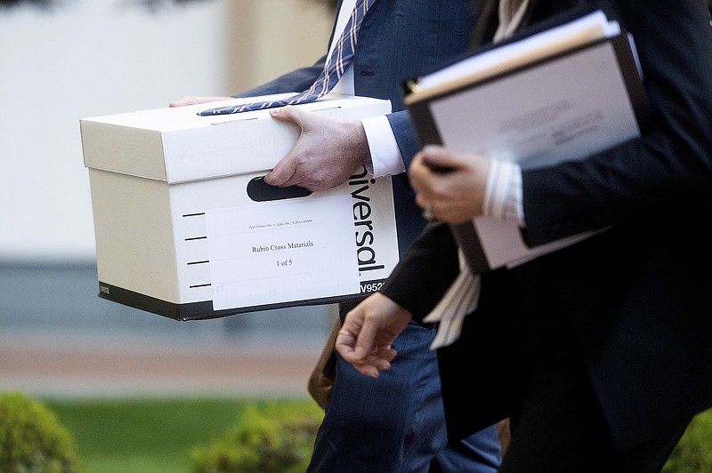 Legal workers carry documents for the Epic Games vs. Apple federal court case into the Ronald V. Dellums building in Oakland, Calif. Epic, maker of the video game Fortnite, charges that Apple has transformed its App Store into an illegal monopoly. (AP Photo/Noah Berger)