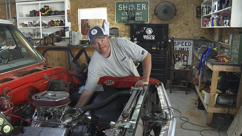 Jason McDowell, who lives in the Forest Manor subdivision works on his antique truck during an interview on May 10, 2021 in Huffman, Texas. He welcomes a proposed $1.7 million storm water mitigation project which could help protect his neighborhood from future flooding. (AP Photo/John L. Mone)