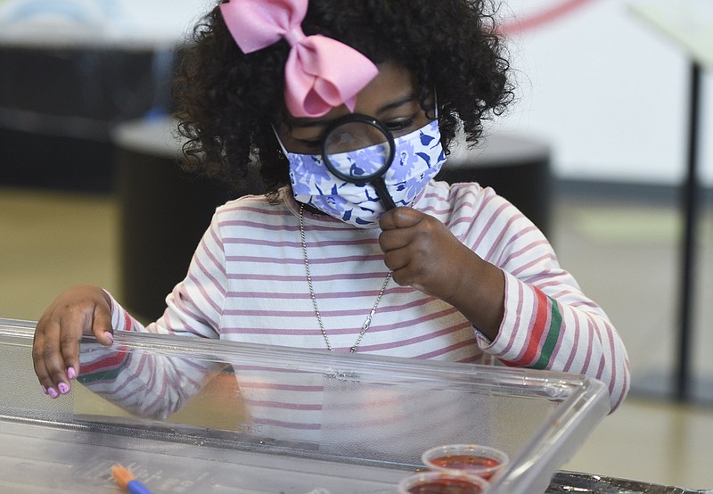 Vivian Flynn of Bentonville examines a pi-shaped piece of ice she is melting using rock salt during Pi Day at the Amazeum in Bentonville. The Amazeum will host a selection of STEAM-based camps this summer.

(NWA Democrat-Gazette File Photo/Charlie Kaijo)