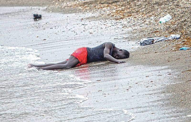 A man lies on the ground on the beach after swimming to the area at the border of Morocco and Spain, at the Spanish enclave of Ceuta, on Tuesday, May 18, 2021. Ceuta, a Spanish city of 85,000 in northern Africa, faces a humanitarian crisis after thousands of Moroccans took advantage of relaxed border control in their country to swim or paddle in inflatable boats into European soil. (AP Photo/Javier Fergo)