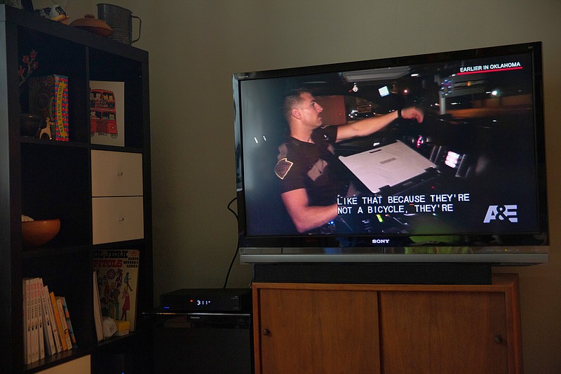 A television at a home in Fort George, N.Y., displays a scene from “Live PD,” a reality television show featuring police officers at work that was canceled in 2020. The Texas state legislature has passed a bill that would make it illegal for reality television crews to film law enforcement officers in the line of duty. (The New York Times/Mengwen Cao)