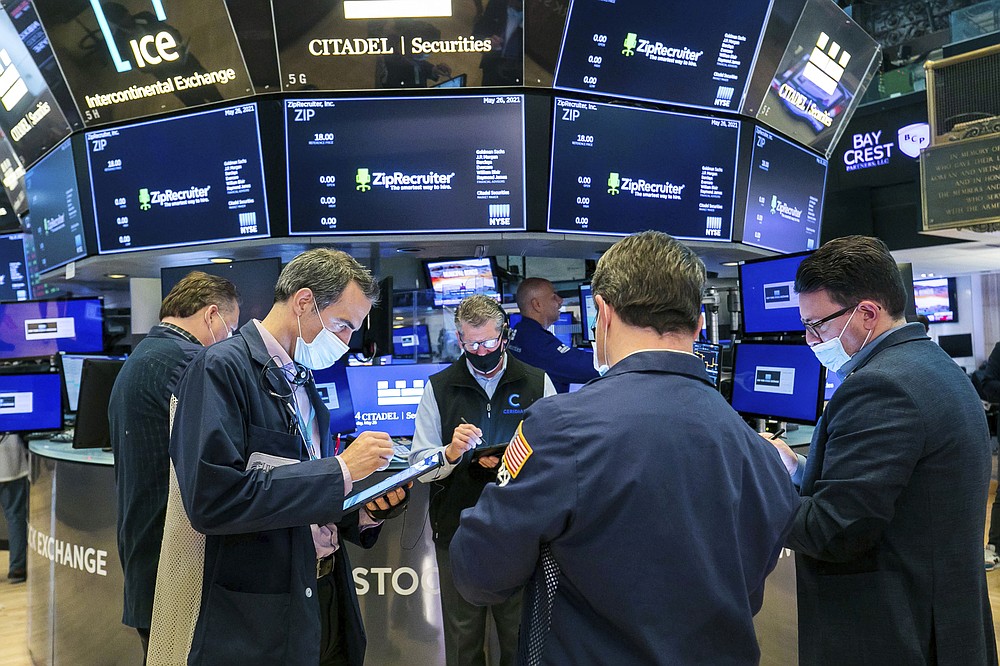 In this photo provided by the New York Stock Exchange, traders gather at a post on the floor, Wednesday, May 26, 2021, in New York. U.S. stocks edged higher in morning trading Wednesday as investors continue to monitor the economic recovery and rising inflation. (Courtney Crow/New York Stock Exchange via AP)