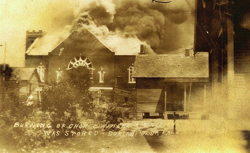 In this photo provided by the Department of Special Collections, McFarlin Library, The University of Tulsa, the Mt. Zion Baptist Church burns during the Tulsa Race Massacre in Tulsa, Okla., on June 1, 1921. (Department of Special Collections, McFarlin Library, The University of Tulsa via AP)