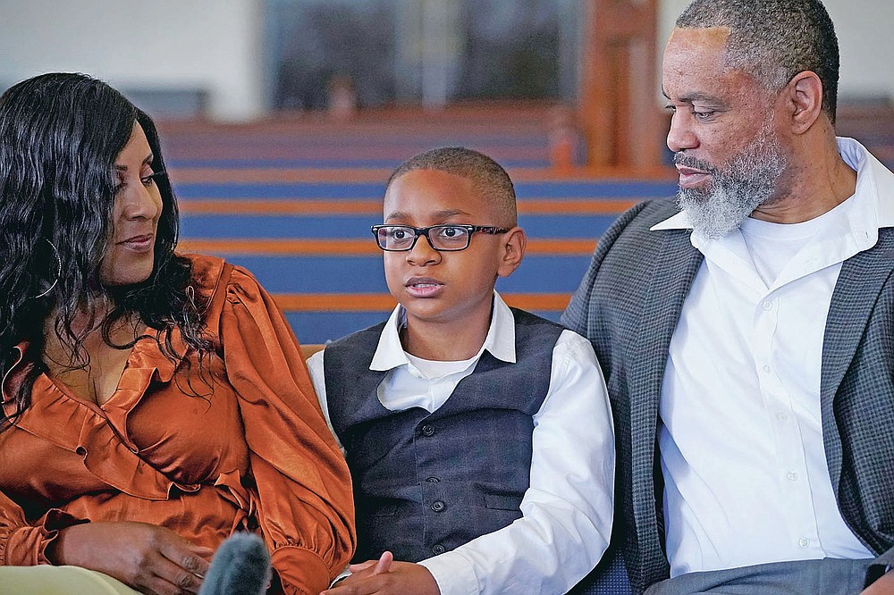 LeRoy "Tripp" Gibbs III, center, 12-year-old great-grandson of Tulsa Race Massacre survivor Ernestine Alpha Gibbs, speaks during an interview with family members in Tulsa, Okla., on Sunday, April 11, 2021. With him are his parents, Tracy and LeRoy Gibbs II. LeRoy II credits his grandmother, who not only built wealth and passed it on, but also showed succeeding generations how it was done. It was a lesson that few descendants of the victims of the race massacre had an opportunity to learn. “The perseverance of it is what she tried to pass on to me,” said LeRoy Gibbs II. AP Photo/Sue Ogrocki)