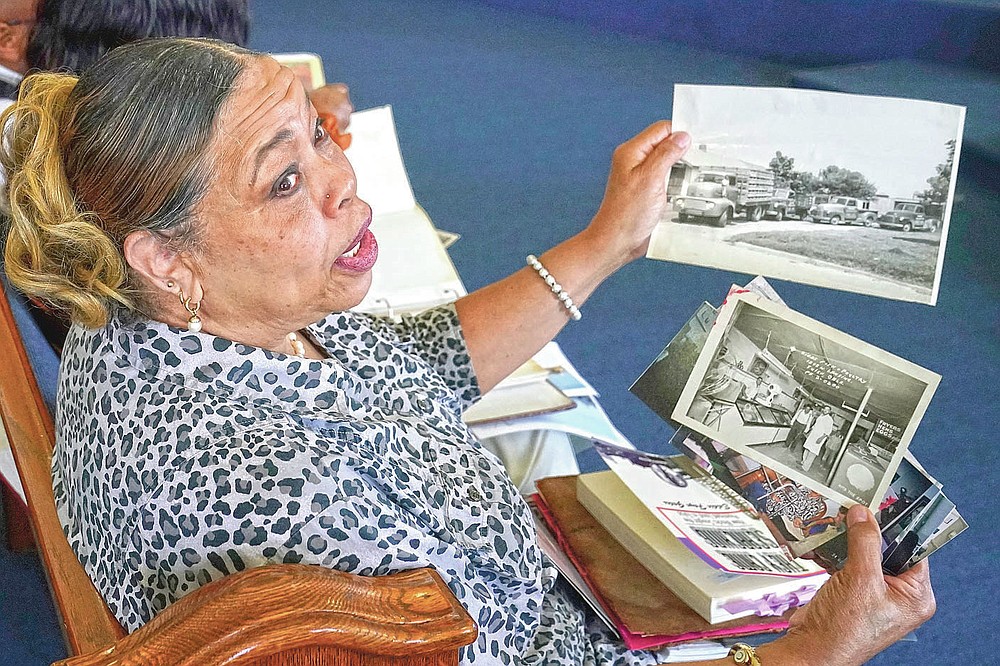 Carolyn Roberts, daughter of Tulsa Race Massacre survivor Ernestine Alpha Gibbs, holds family photos of the Gibbs family business during an interview in Tulsa, Okla., on Sunday, April 11, 2021. Roberts said although her parents lived with the trauma of the massacre, it never hindered their work ethic: “They survived the whole thing and bounced back.” (AP Photo/Sue Ogrocki)