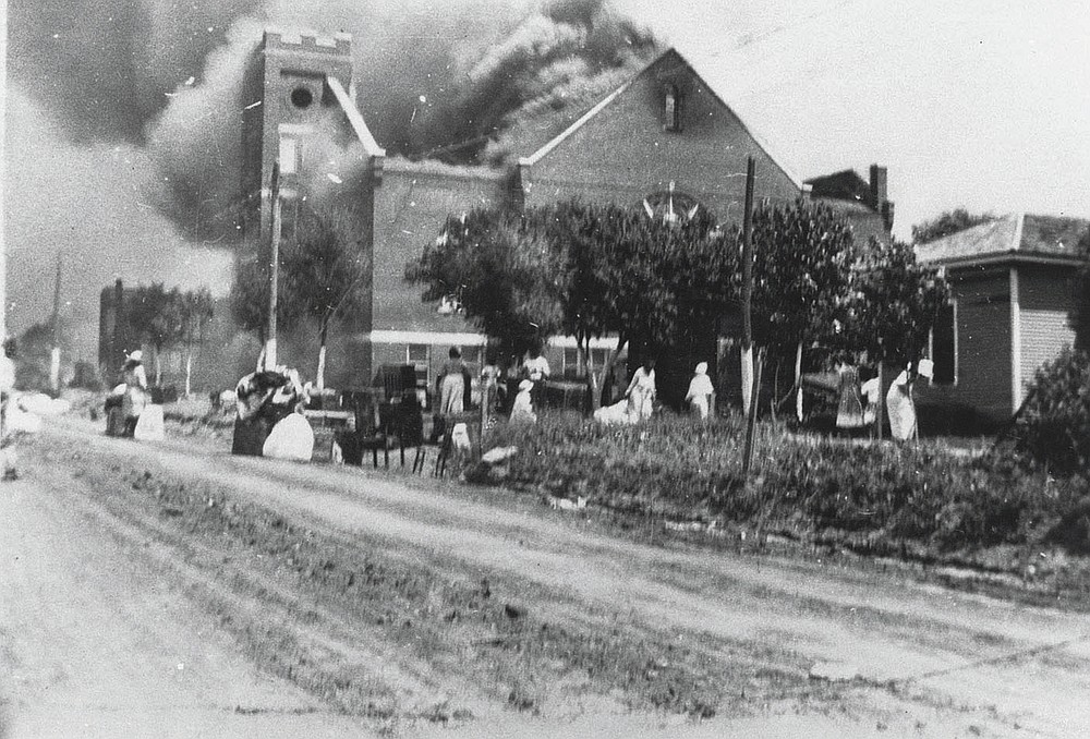 In this photo provided by the Department of Special Collections, McFarlin Library, The University of Tulsa, the Mt. Zion Baptist Church burns in Tulsa, Okla. during the Tulsa Race Massacre of June 1, 1921. (Department of Special Collections, McFarlin Library, The University of Tulsa via AP)