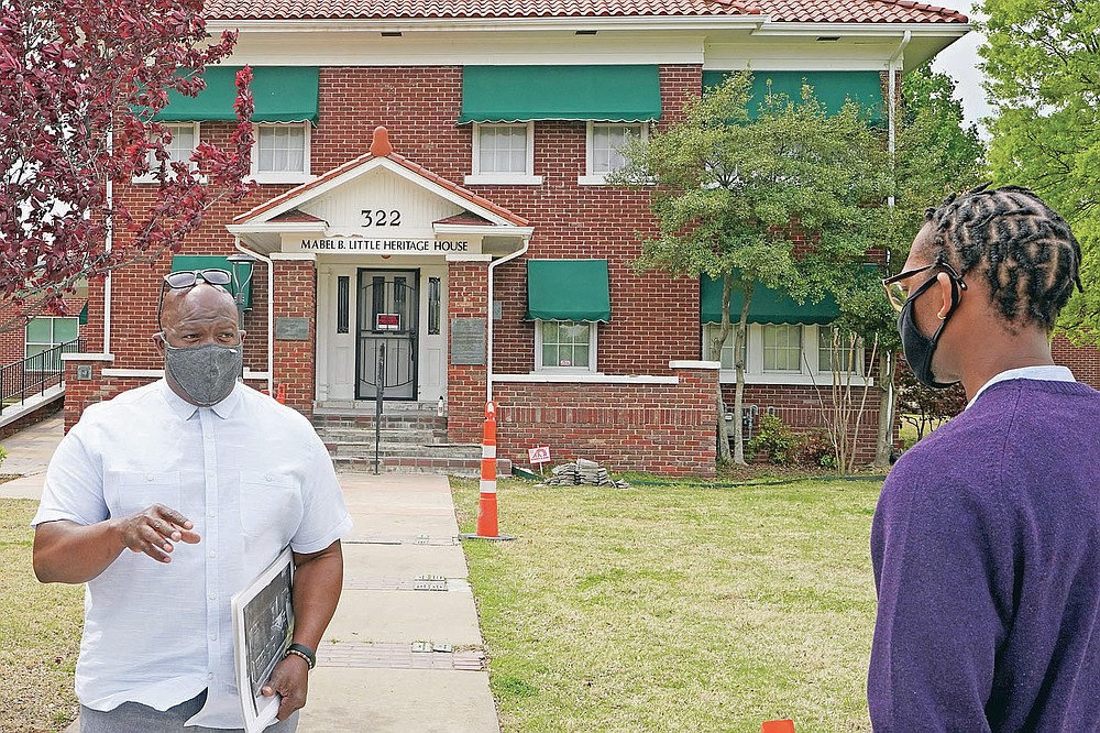 Chief Egunwale Amusan, stands in front of the Mabel B. Little Heritage House while leading a Black Wall Street tour in Tulsa, Okla., on Monday, April 12, 2021. “I’ve read every book, every document, every court record that you can possibly think of that tells the story of what happened in 1921,” Amusan told the tour group. “But none of them did real justice. This is sacred land, but it’s also a crime scene.” (AP Photo/Sue Ogrocki)