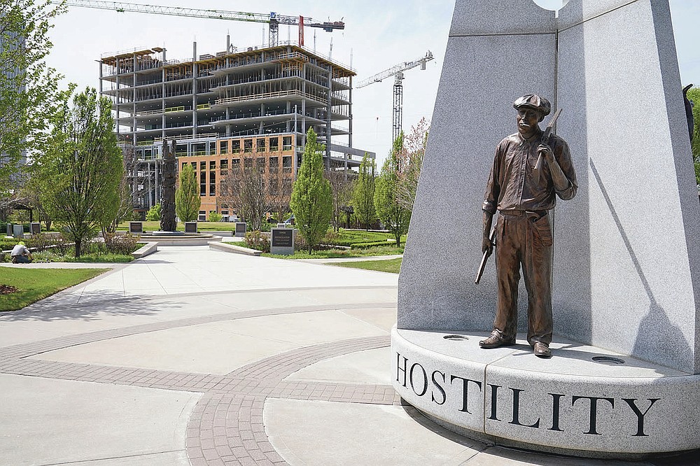 A sculpture commemorating the Tulsa Race Massacre stands in John Hope Franklin Reconciliation Park in Tulsa, Okla., Wednesday, April 14, 2021, with new construction in the background. (AP Photo/Sue Ogrocki)