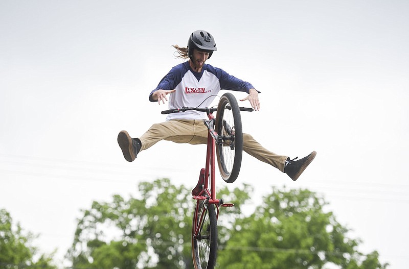 Connor Williamson of All Bikes All Day NWA performs bike tricks for attendees, Thursday during the Arkansas Good Roads Foundation Safe Roads Summit at the Thaden Fieldhouse in Bentonville. The event featured keynote presentations, panel discussions and a performance from All Bikes All Day NWA. The Safe Roads Summit is one of the largest policy-focused bike events in Arkansas this year. Speakers discussed the topic of bicyclist's safety on roads. Check out nwaonline.com/210528Daily/ for today's photo gallery. 
(NWA Democrat-Gazette/Charlie Kaijo)