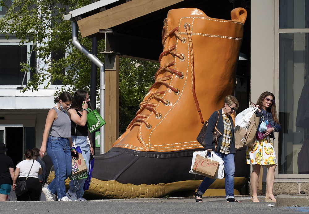 Shoppers walk past a giant LL Bean boot outside the Ross Park Mall in Pittsburgh Sunday, May 23, 2021. With vaccinations rolling out and shoppers freer to go out maskless, retailers are seeing an eager return to their stores after months of  watching their customers focus on online buying during the pandemic. (AP Photo/Gene J. Puskar)