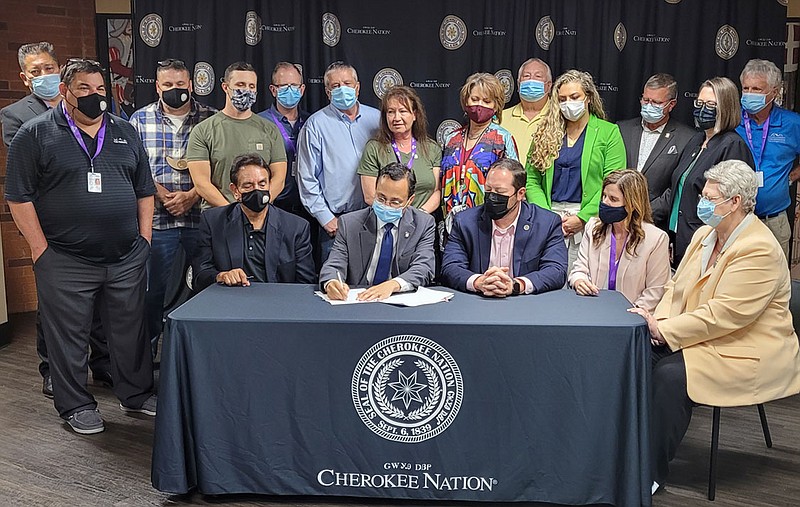 Photo Submitted Principal Chief Chuck Hoskin Jr.(second from right seated), Deputy Chief Bryan Warner, Treasurer Tralynna Sherrill Scott and Secretary of State Tina Glory Jordan joined Tribal Councilors to sign legislation Thursday that will provide a $2,000 lump sum COVID relief individual assistance payment to all 392,832 Cherokee Nation citizens.