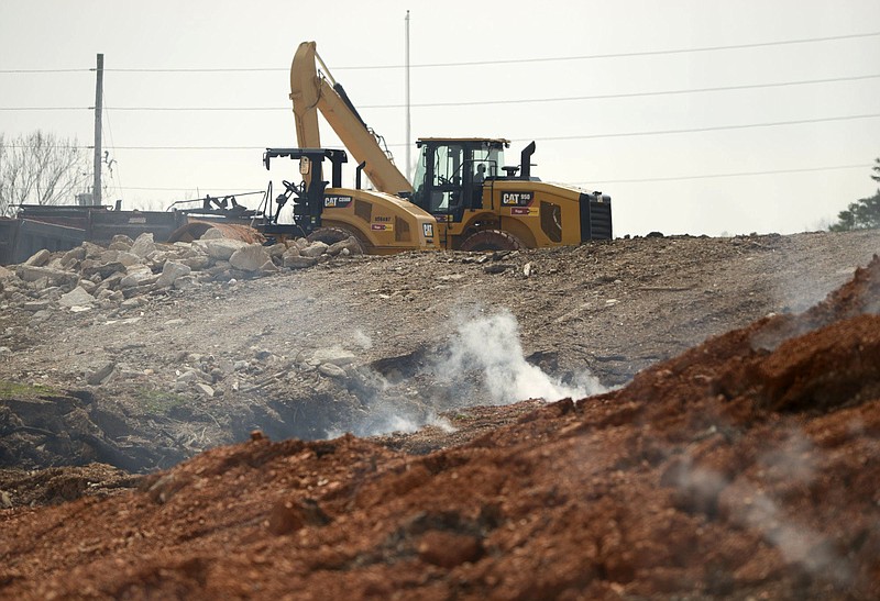 Crew members work at the site of the stump dump, Friday, April 5, 2019 in Bella Vista. (NWA Democrat-Gazette File Photo/CHARLIE KAIJO)