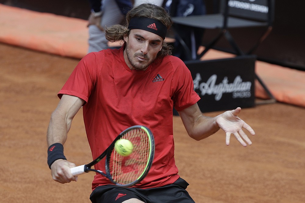 FILE - In this May 15, 2021 file photo, Greece's Stefanos Tsitsipas returns the ball to Serbia's Novak Djokovic during their quarter-final match at the Italian Open tennis tournament, in Rome. When the French Open starts Sunday, May 30, in Paris, there will be those looking for a changing of the guard in men’s tennis, Tsitsipas and Alexander Zverev are among the 20-somethings considered contenders. (AP Photo/Gregorio Borgia, File)