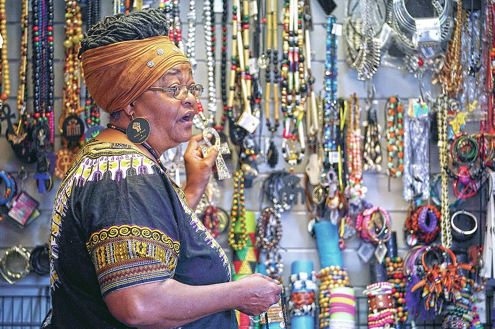 Billie Parker, owner of the Black Wall Street Market, displays some of the items she has for sale in Tulsa, Okla., on Saturday, April 10, 2021. Her establishment, in an underdeveloped and underserved section of the city, is a far cry from the booming city within a city that was Greenwood, with its Black grocers, shopkeepers, doctors, lawyers, newspaper publishers and other businessmen and women. But Parker thought it was important to lay claim to the name and its legacy. (AP Photo/Sue Ogrocki)