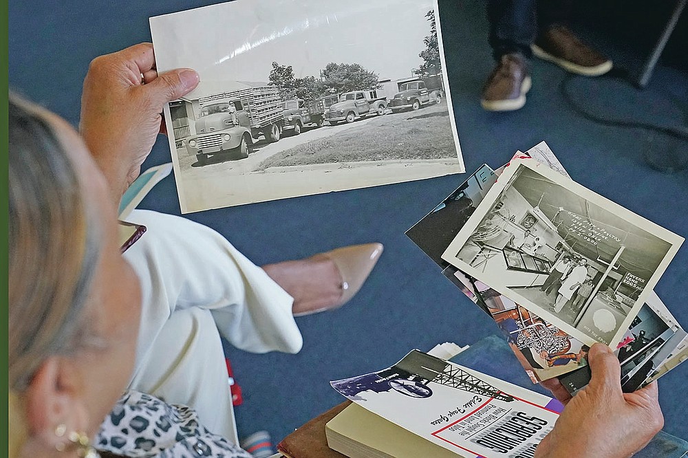 Carolyn Roberts, daughter of Tulsa Race Massacre survivor Ernestine Alpha Gibbs, holds photos of the Gibbs' former family businesses during an interview in Tulsa, Okla., on Sunday, April 11, 2021. Today, the Gibbs Next Generation Center, a small shopping mall and office park run by descendants of Ernestine, is located on the property which used to be the location of the businesses run by Roberts' parents. (AP Photo/Sue Ogrocki)