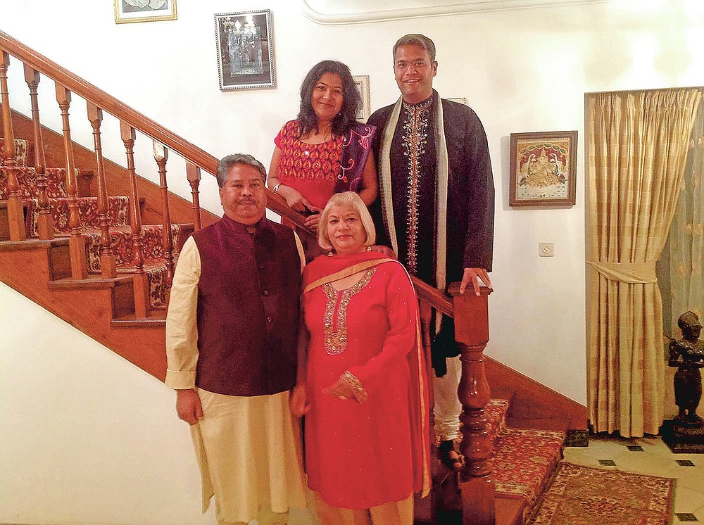 In this undated photo provided by Amrohi family, Yamini Amrohi, front right, poses with her children and late husband Ashok Amrohi, front left, who died of COVID-19, in Maputo, Mozambique. Ashok, a medical doctor before joining the diplomatic corps, had traveled the world. He'd been ambassador to Algeria, Mozambique and Brunei, and had retired to Gurgaon, a city just outside the capital, and a life of golf and piano lessons. (Amrohi family via AP)