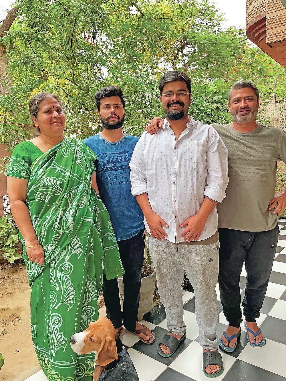 In this photo provided by Chakravorty family, family members of Prabir Chakravorty, 73, a COVID-19 survivor, pose for a photograph at their home in New Delhi, India, Monday, May 17, 2021. Chakravorty, the family patriarch and widower, a construction executive was treated at home for the coronavirus. (Chakravorty family via AP)