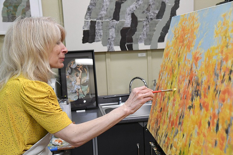 Dolores Justus paints on an unnamed painting in the sudio space in Justus Fine Art Gallery. - Photo by Tanner Newton of The Sentinel-Record