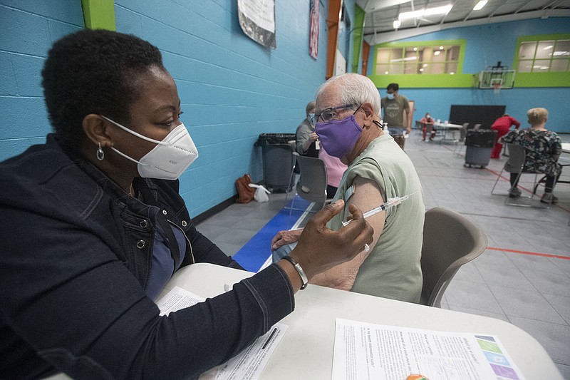 Oluyemisi Adelusimo, public health nurse for the Arkansas Department of Health administers a covid-19 vaccine to Kenny Hill of  Bella Vista Wednesday May 26, 2021 at the Rogers Activity Center. Visit nwaonline.com/210530Daily/ and nwadg.com/photo. (NWA Democrat-Gazette/J.T. Wampler)